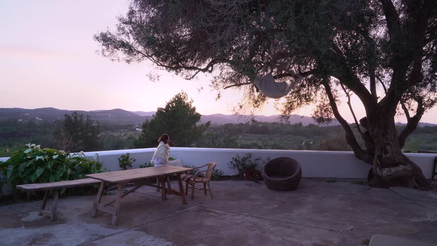 Woman looking over a valley and enjoying the sunrise /sunset with a majestic view.