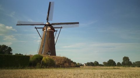Typical Dutch Windmill in the back. Man passes by.