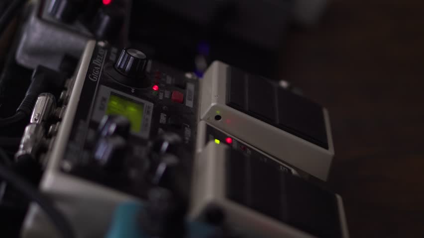 Man uses hit foot and shuffles through presets on his guitar effects pedal | Shutterstock HD Video #1018931773