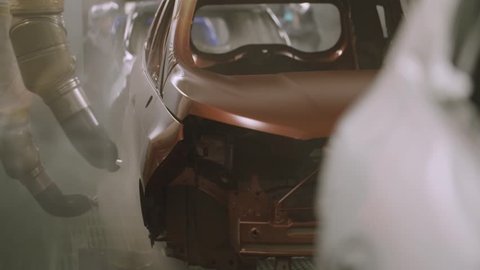 Slow motion painting department inside a car factory. Automotive industry
