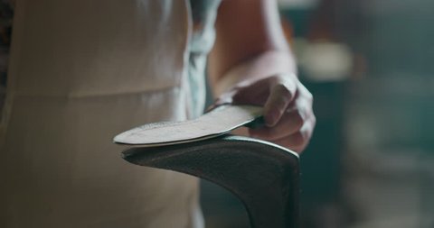 Close up of a shoemaker glueing the leather on the shoes in a shoe factory. Concept: handmade, fashion, industrial, factory.