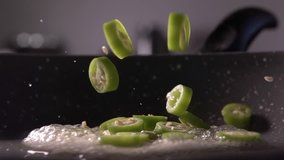 Chopped green pepper being dropped into a frying pan in slow motion, 240 fps - Powered by Shutterstock - Get 15% off with code: PIKWIZARD15