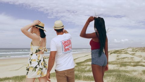 Young attractive couple walking having fun dancing with sand dunes and wide open sky in the background in Australia. Medium close up on 4k RED camera.