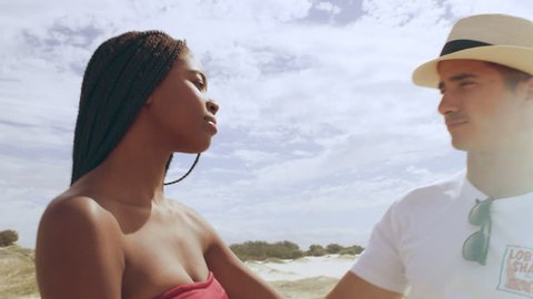Young attractive couple walking and holding hands with sand dunes and wide open sky in the background in Australia. Close up on 4k RED camera.