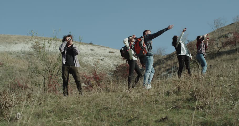 Break time at exhibition for group of friends who are tired , in the middle of mountain, they are relaxing for a bit taking pictures.
