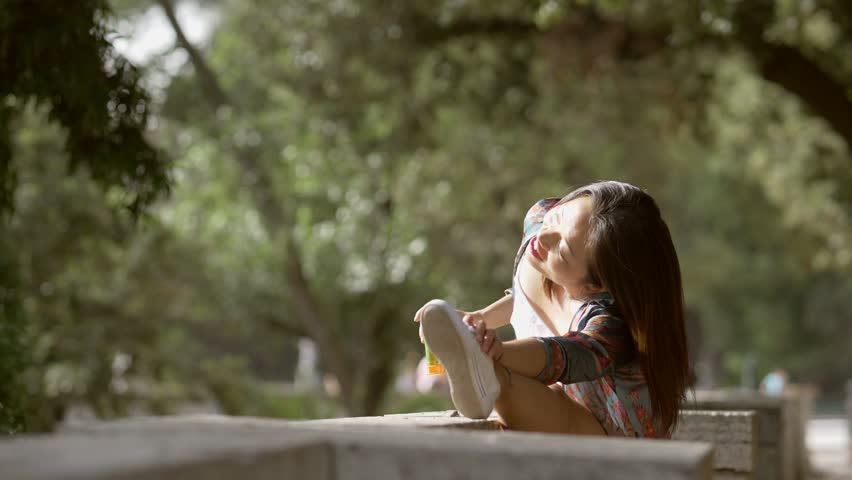sport, wellbeing, nature. smiling asian young woman making stretching in the park