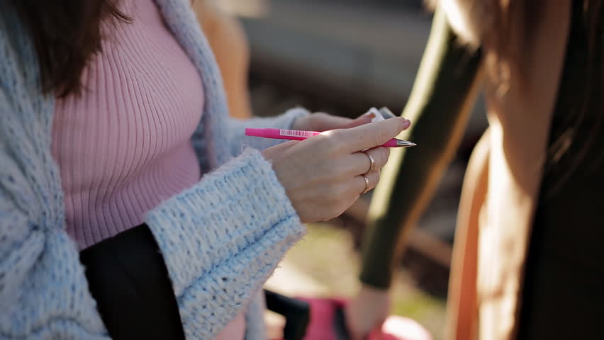 Girl at the railway station writing on a piece of paper your address and phone number