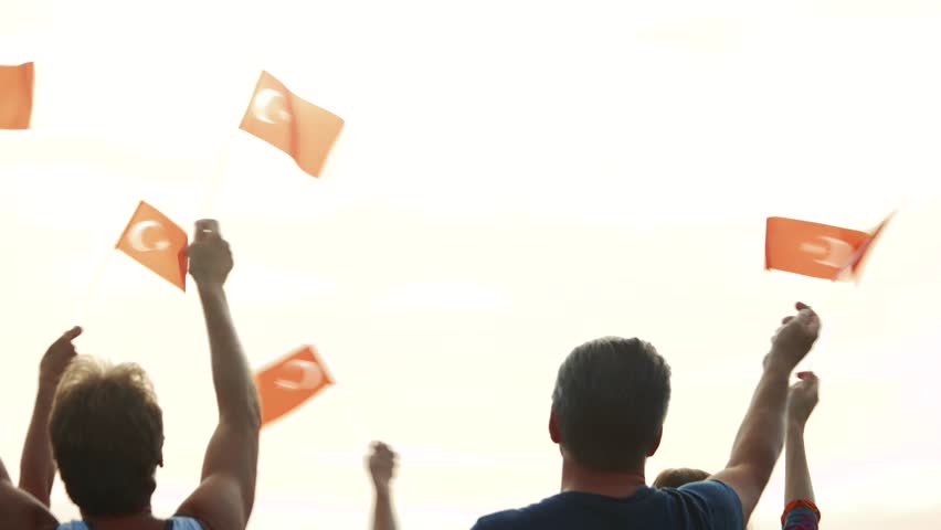 People holding the flags of Turkey. Turkish patriots celebrating Independence Day with raised flags outdoors, back view. Patriotic party concept. Royalty-Free Stock Footage #1018960330