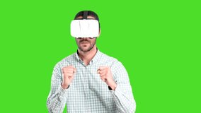 Video of a concentrated young man using a virtual reality glasses