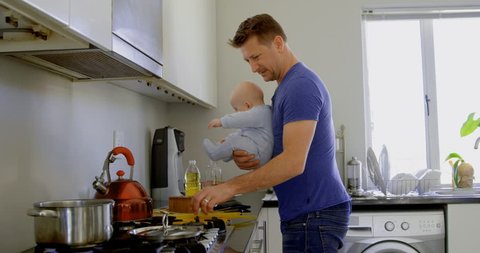 Father with his baby boy preparing food in kitchen at home Social distancing and self isolation in quarantine lockdown for Coronavirus Covid19