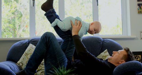 Father playing with his baby boy in living room at home Social distancing and self isolation in quarantine lockdown for Coronavirus Covid19