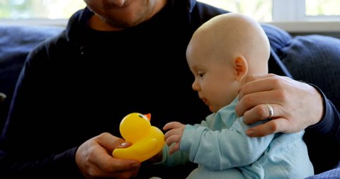 Close up of baby boy with his father playing with toy at home Social distancing and self isolation in quarantine lockdown for Coronavirus Covid19