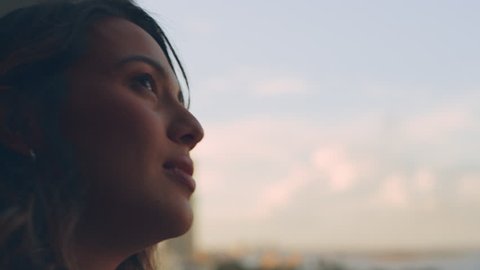 Beautiful, young, caucasian woman stands on a balcony and looks into the distance in deep thought in natural daylight, in Australia. Medium shot in 4K on a RED camera