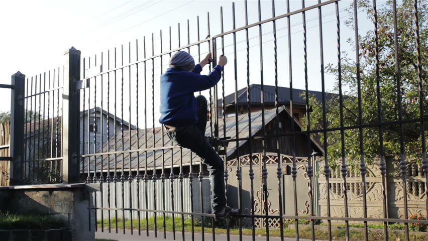 boy on the fence,boy climbed a metal fence and swinging