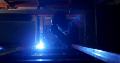 Attentive metalsmith using welding torch in workshop