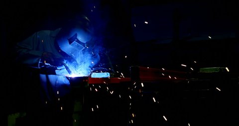 Attentive metalsmith using welding torch in workshop 
