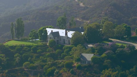 Aerial view of mountain range suburban mansions in Brentwood area on a sunny day in Los Angeles, California. Shot on 4K RED camera.