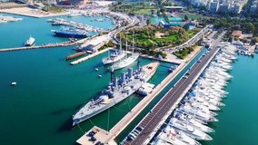 Aerial drone bird's eye view video of small port and Park of Maritime Tradition where historic Averof warship is docked, Floisvos, Faliro Marina, Attica, Greece