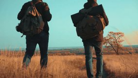 people tourists travel lifestyle in nature the autumn go on the road path adventure . slow motion video. two hiker with outdoor backpacks hiking. tourist concept the travel man tourism