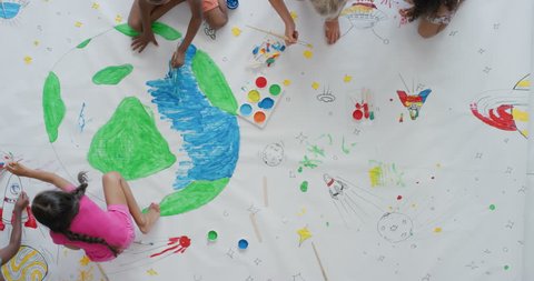 multi ethnic children paint colorful pictures together on paper using paint brushes happy kids enjoying fun creativity painting science fiction space drawing pictures top view