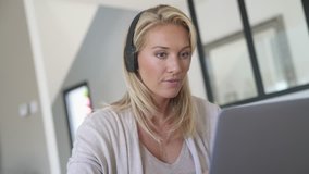 Businesswoman working from home-office, using headset