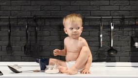 Children love sugar or sweets. Cute toddler sitting on kitchen table tasting sugar out of sugar bowl when left alone in kitchen. 4k - Powered by Shutterstock - Get 15% off with code: PIKWIZARD15