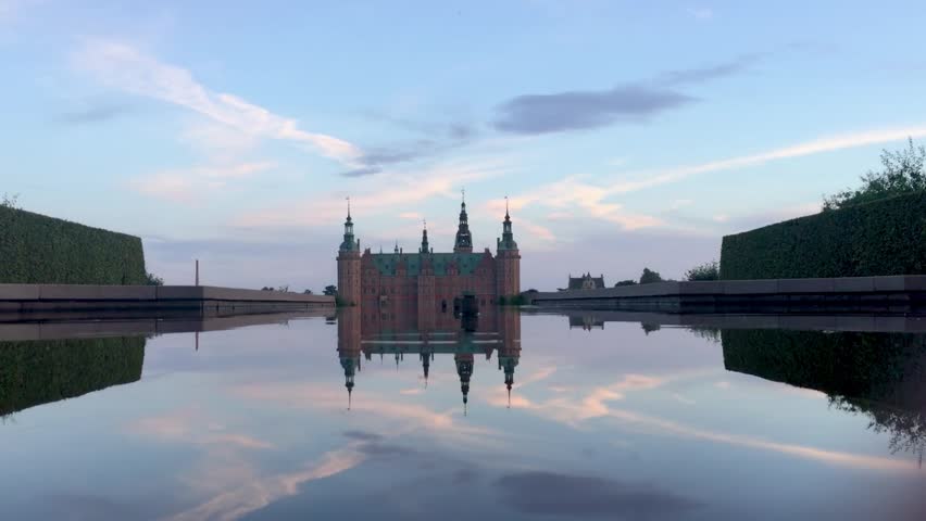 Frederiksborg Castle, in the Danish city of Hillerod, seen from one of the water fountains of its garden at dawn. Establishing/ long shot. Royalty-Free Stock Footage #1019008204