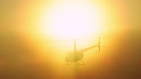 Aerial view of helicopter flying over mountains into the clouds during beautiful sunset in Los Angeles, California. Wide long shot on 4K RED camera.