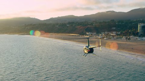 Aerial view of helicopter flying over beach cliff houses during beautiful sunset in Los Angeles, California. Best Los Angeles Aerial shot. Wide long shot on 4K RED camera.