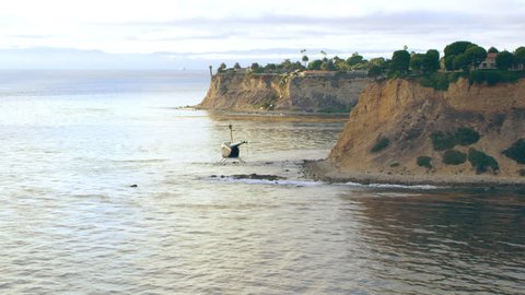 Amazing California shoreline. Aerial view of helicopter flying over ocean cliffs bluffs during golden hour in Los Angeles, California. Wide long shot on 4K RED camera.