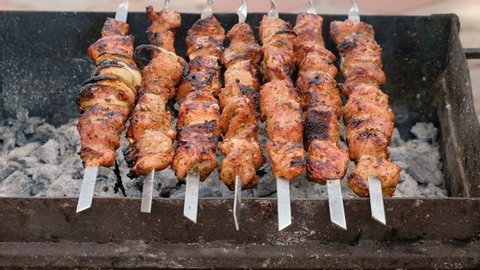 Description: Grilling marinated shashlik (skewered meat) on a grill. Hot birch coal. Fresh juicy meat. Healthy food. Holidays BBQ.
