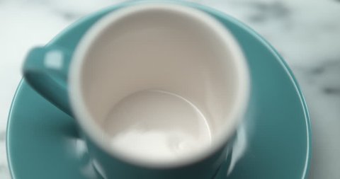 Barista pourring espresso in blue small cup closeup with 4k Phantom Flex camera