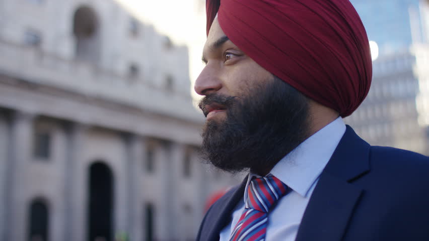 Sikh business man looking around the city, in slow motion 