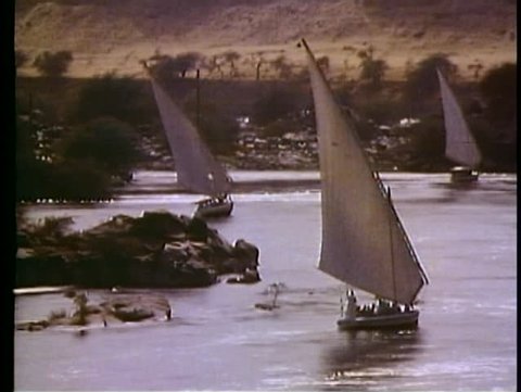 ASWAN, EGYPT, 1977, The Nile River, feluccas, sailboats, three boats, backlit