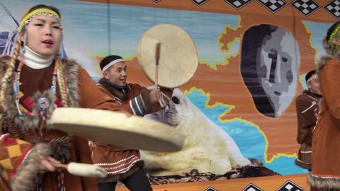KAMCHATKA PENINSULA, RUSSIA - NOV 4, 2018: Women and men in national clothing indigenous inhabitants Kamchatka dancing with tambourine. Celebration of Koryak national holiday Hololo (Day of Seal).