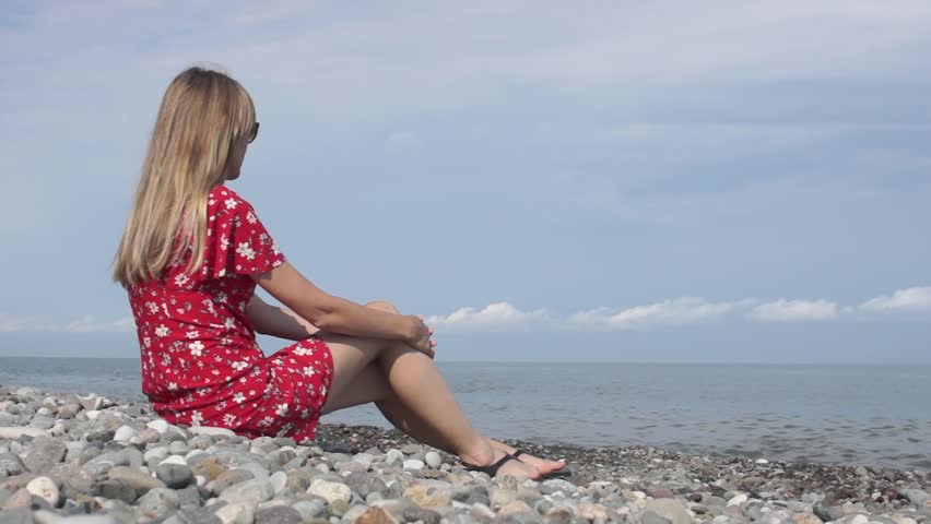 girl in red dress on the beach. thoughts about life on the beach