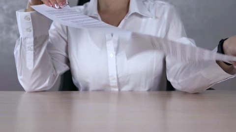 A serious business woman tearing a contract in pieces