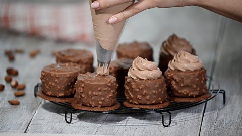 Decorating chocolate mini mousse cake. Chocolate Hazelnut Mousse Cake covered with chocolate glaze.