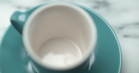 Barista pourring espresso in blue small cup closeup with 4k Phantom Flex camera