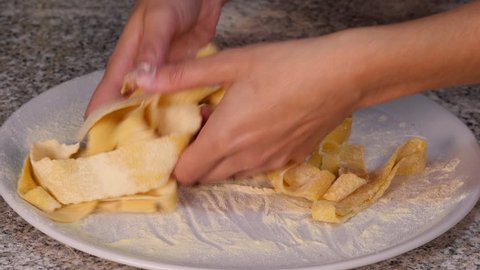 hand takes homemade fresh pappardelle
