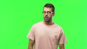 Man on green screen chroma key background with fingers crossing and wishing the best. Making a wish