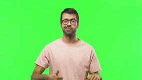 Man on green screen chroma key background making good-bad sign. Undecided person between yes or not