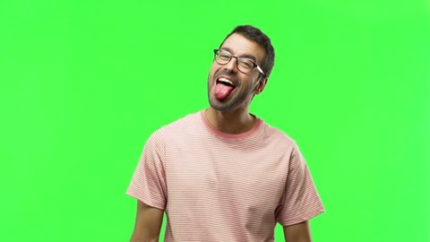 Man on green screen chroma key background makes funny and crazy face emotion
