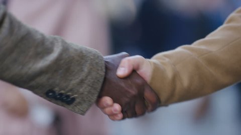 Handshake between two men in the city, in slow motion