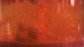 Abstract video. Bright orange background, liquid substance, water or other with red foam, air bubbles rising up and down. Effervescent geyser raises many bubbles from the bottom, chemical reaction