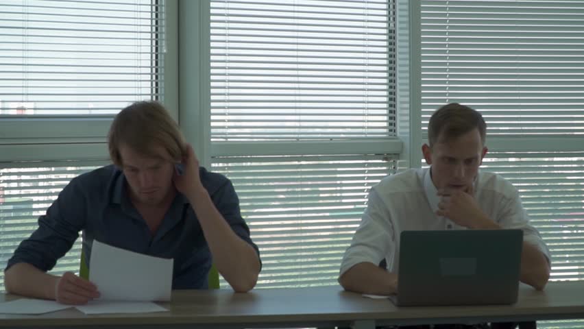 Two men sit at the table in the office