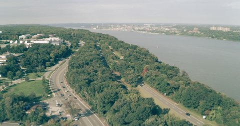 Aerial view of houses tucked away in green forest on island in New York during the day under overcast blue sky. Wide shot on 4K RED camera.