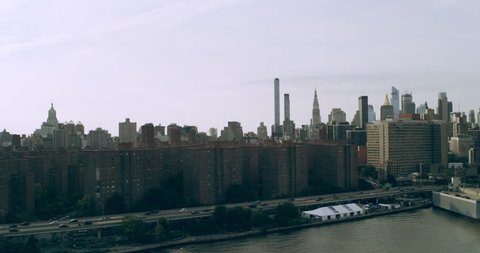 Aerial view of Manhattan skyine skyscrapers from river in New York during the day under blue skies. Wide shot on 4K RED camera.