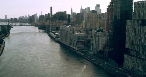 Aerial view of Manhattan skyine skyscrapers from river with boats on it in New York during the day under blue skies. Wide shot on 4K RED camera.