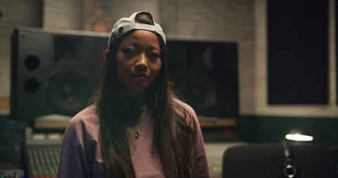 Funky dancer grooving and dancing in front of professional mixing board in a recording studio. Medium shot on 4K RED camera.
